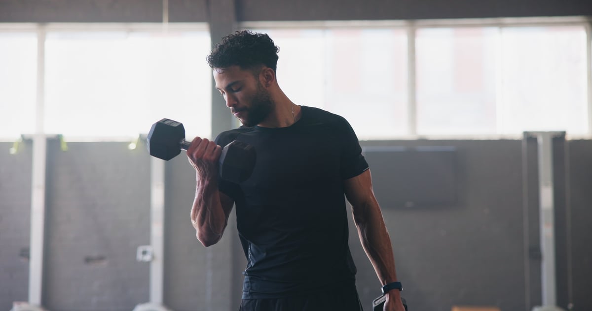 Dumbbells, fitness and man in gym, training and energy with exercise, strength and challenge