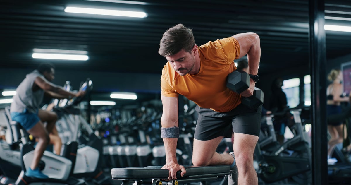 Fitness, man and training with dumbbell row in gym for muscle development, power and energy